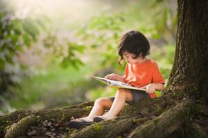 boy reading under a tree
